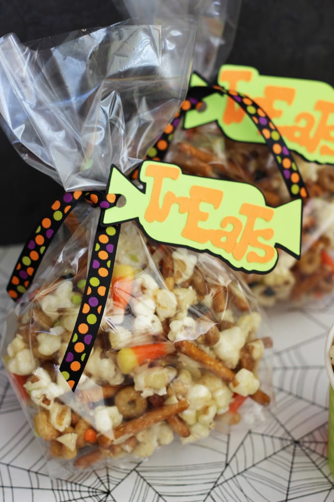 Gooey Halloween Popcorn Crunch - Popcorn, pretzels, candy corn, almonds, and cereal all mixed up in the most wonderfully addicting sugar coating!