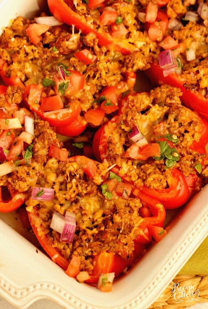 Skinny Taco Stuffed Peppers make a great high-protein, low carb meal prep idea!  They are filled with taco flavor and topped with tomatoes, red onion, cilantro, and shredded cheese.