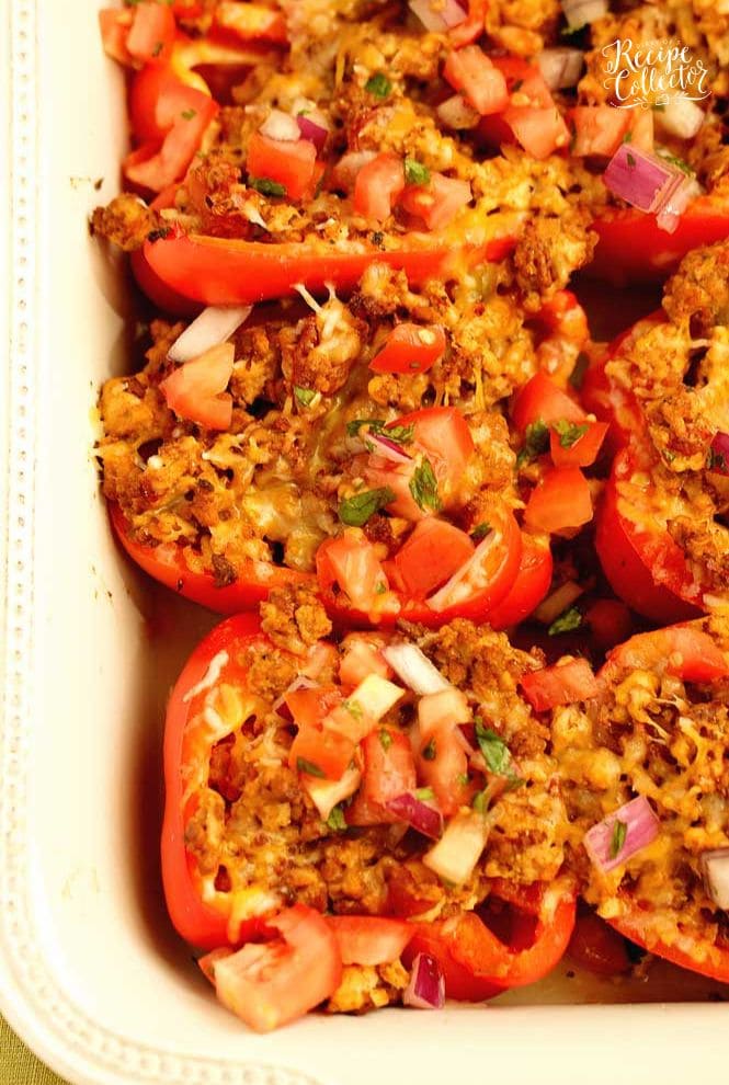 Skinny Taco Stuffed Peppers make a great high-protein, low carb meal prep idea!  They are filled with taco flavor and topped with tomatoes, red onion, cilantro, and shredded cheese.