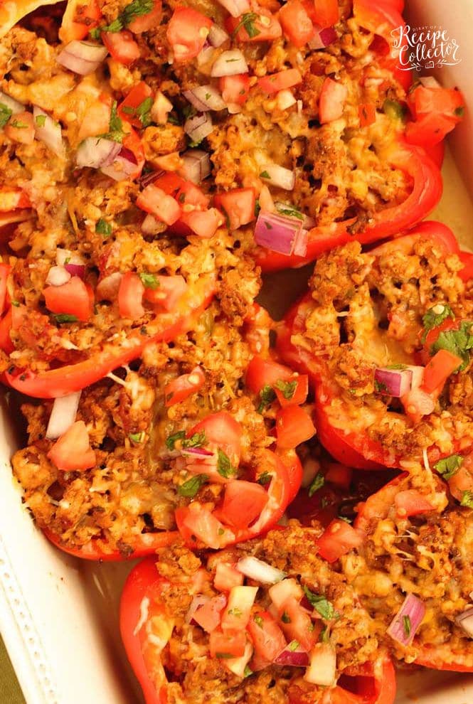 Skinny Taco Stuffed Peppers make a great high-protein, low carb meal prep idea!  They are filled with taco flavor and topped with tomatoes, red onion, cilantro, and shredded cheese.